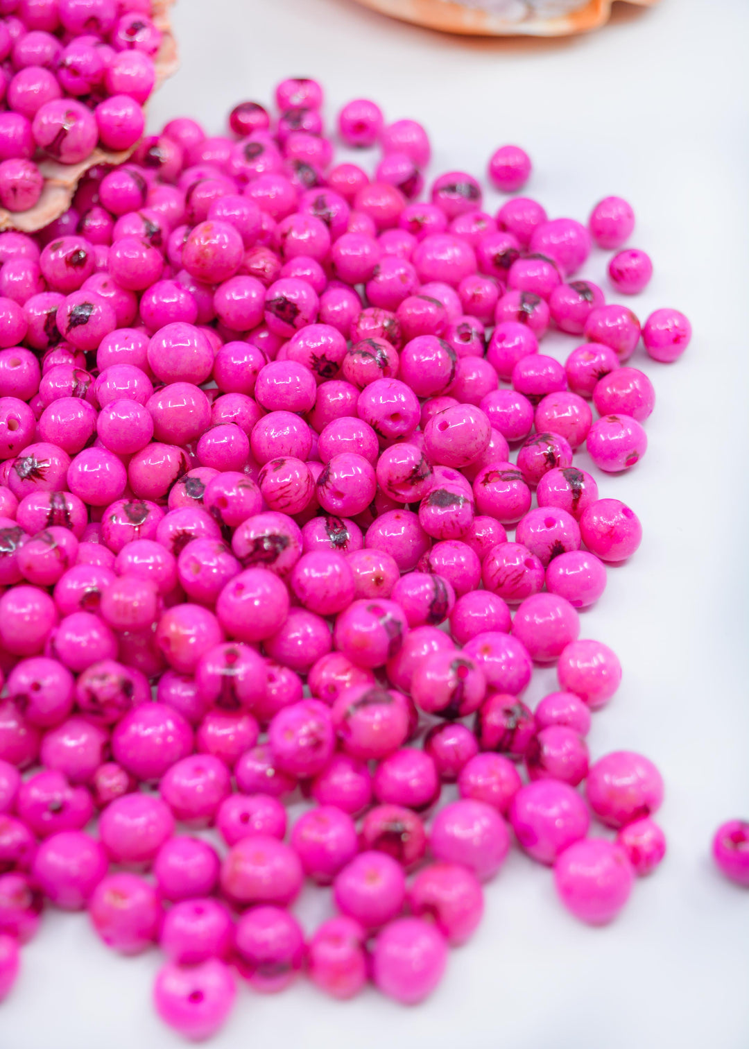 Beautiful shiny pink acai beads displaying the natural sizes of the beads.
