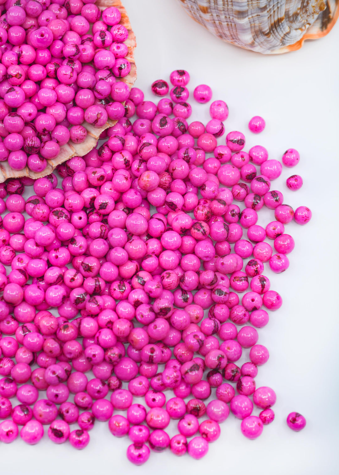 Beautiful shiny Pink Acai Beads showing the different natural beads sizes.