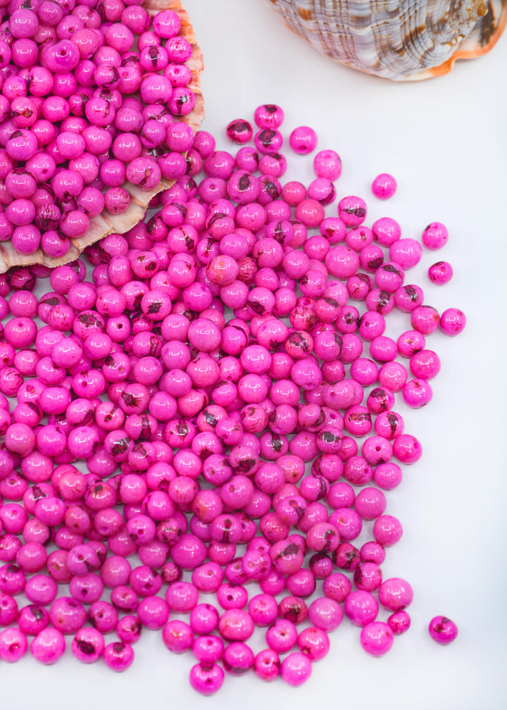 Beautiful shiny Pink Acai Beads showing the different natural beads sizes.
