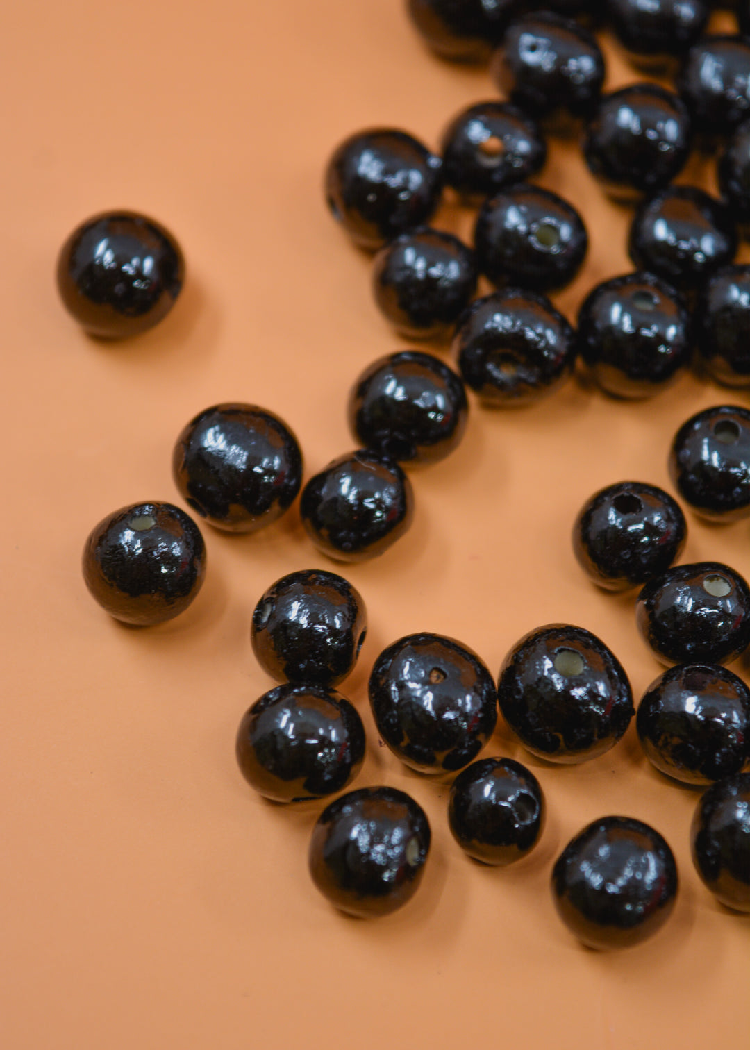 Black Natural Acai beads from the Amazon, showing the variance in the bead size.