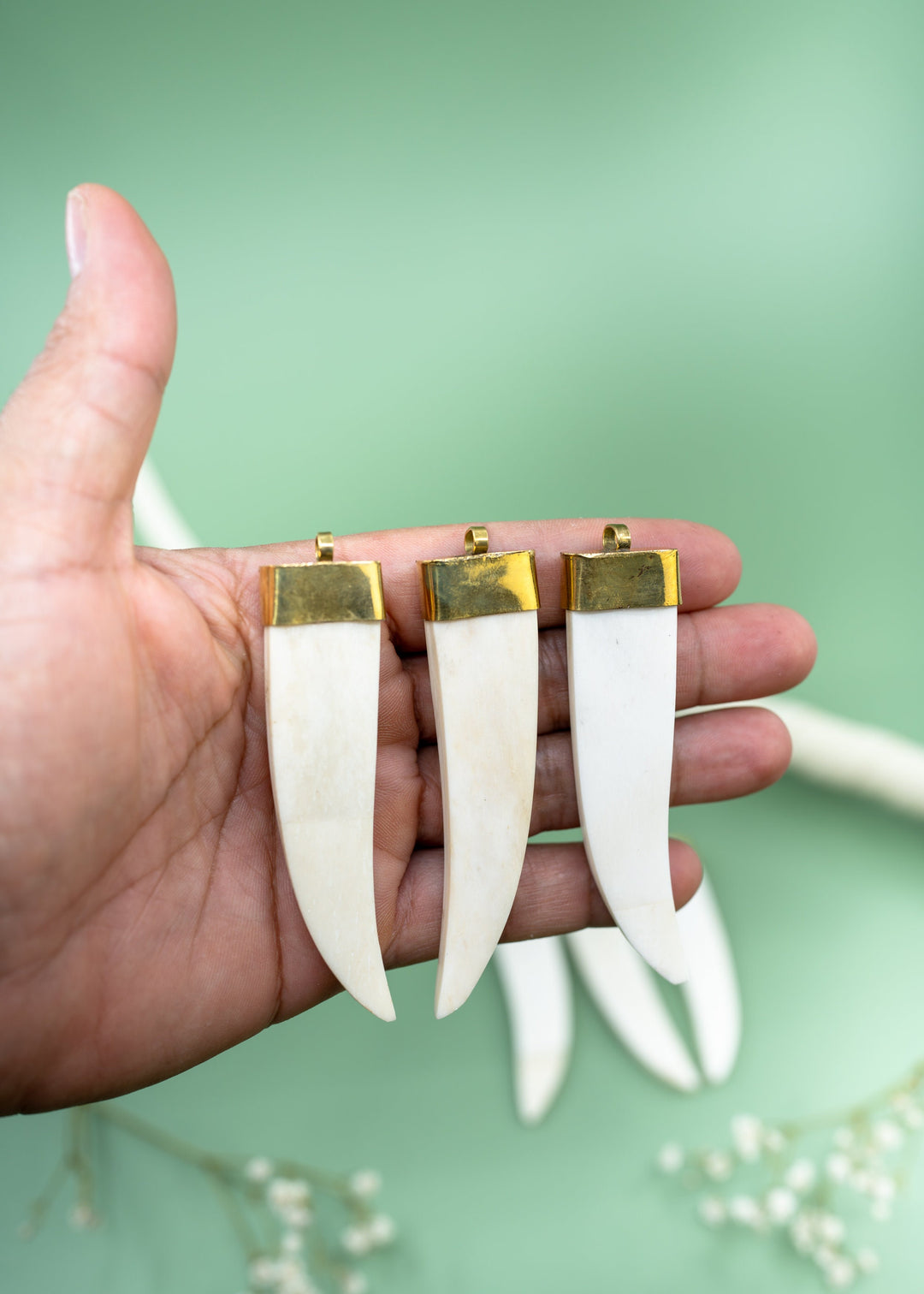 Cream white bone tusk pendant handmade in India from recycled cow bone featuring a polished gold-tone cap. Lightweight tribal-inspired focal pendant perfect for boho jewelry making, macrame necklaces, artisan designs, and statement jewelry.