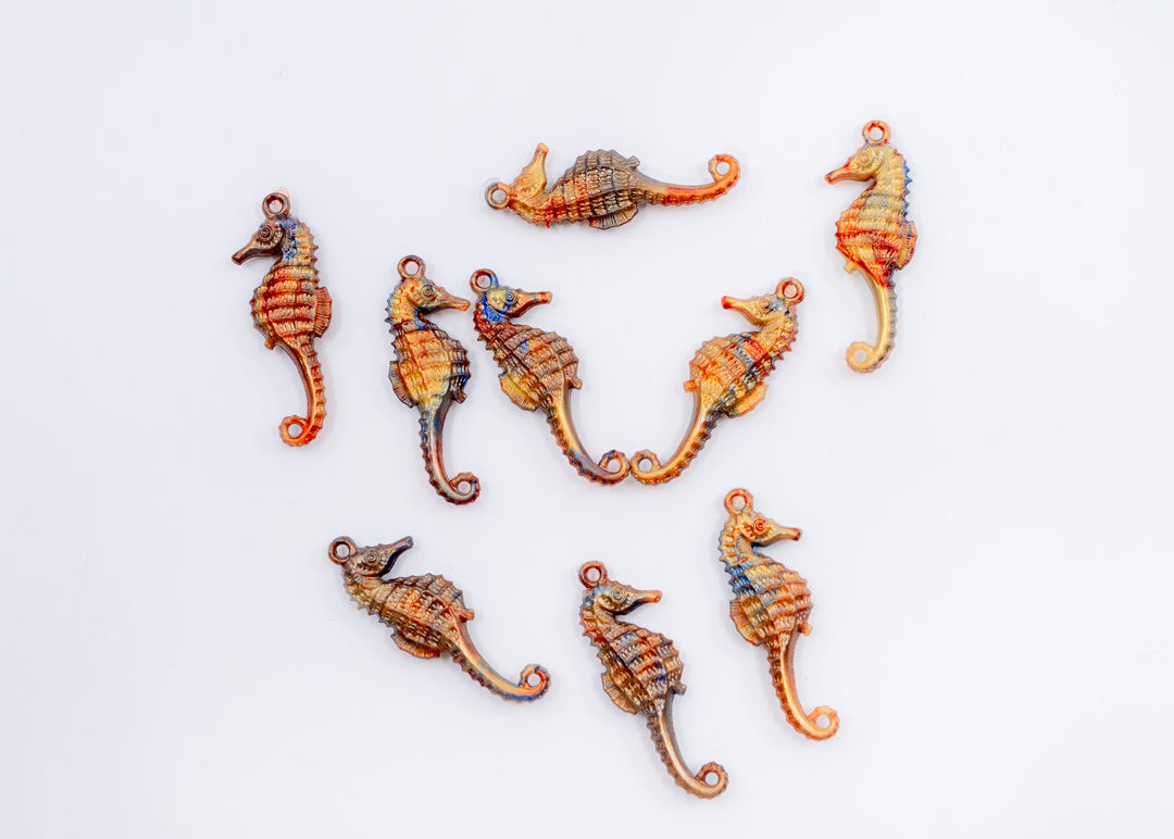 Tiny bronze and blue seahorse charm handmade from waterproof German resin. Lightweight ocean-inspired pendant perfect for beach jewelry, coastal accessories, earrings, charm necklaces, sweater pins, and mermaid-inspired designs.