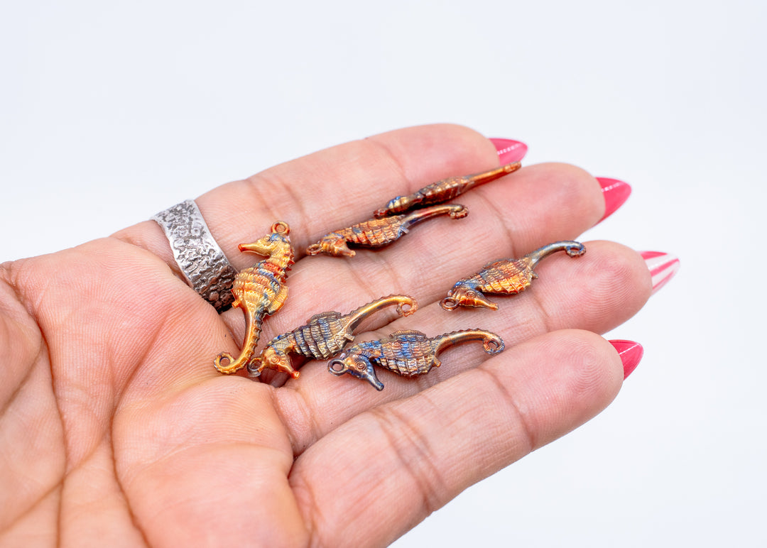 Tiny bronze and blue seahorse charm handmade from waterproof German resin. Lightweight ocean-inspired pendant perfect for beach jewelry, coastal accessories, earrings, charm necklaces, sweater pins, and mermaid-inspired designs.