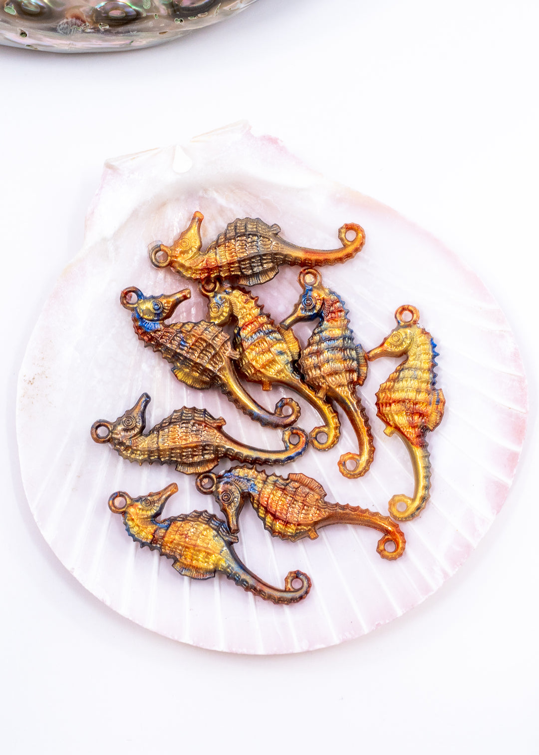 Tiny bronze and blue seahorse charm handmade from waterproof German resin. Lightweight ocean-inspired pendant perfect for beach jewelry, coastal accessories, earrings, charm necklaces, sweater pins, and mermaid-inspired designs.