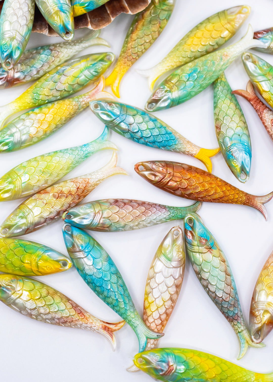 A collection of small, fish-shaped made from German resin charms with detailed scales, displayed in a flat-lay arrangement on a clean white background.