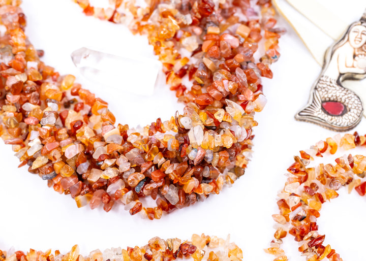 Natural Carnelian chip beads featuring warm orange and red semi-precious gemstone chips on a 34 inch strand. Perfect for boho jewelry making, crystal-inspired designs, bracelets, necklaces, malas, earrings, and artisan gemstone creations.