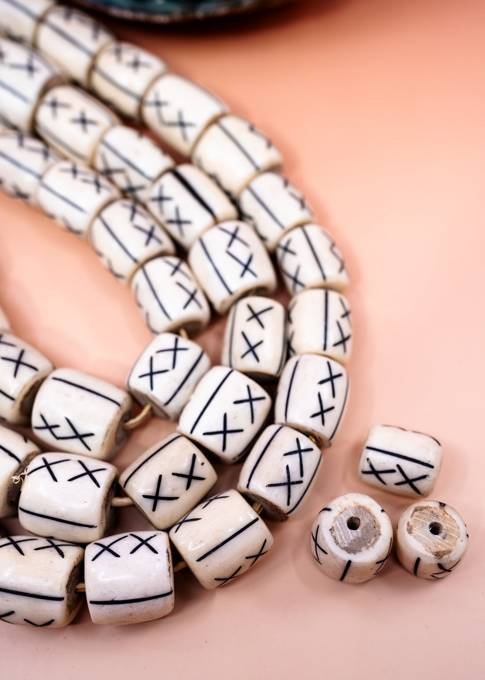 Hand-carved African bone beads handmade in Kenya from recycled cow bone featuring bold tribal X patterns and oversized barrel shapes. Perfect for boho jewelry making, statement necklaces, leather cord projects, macrame, braids, and artisan designs.