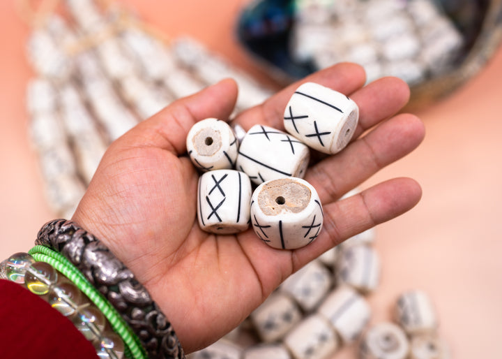 Hand-carved African bone beads handmade in Kenya from recycled cow bone featuring bold tribal X patterns and oversized barrel shapes. Perfect for boho jewelry making, statement necklaces, leather cord projects, macrame, braids, and artisan designs.