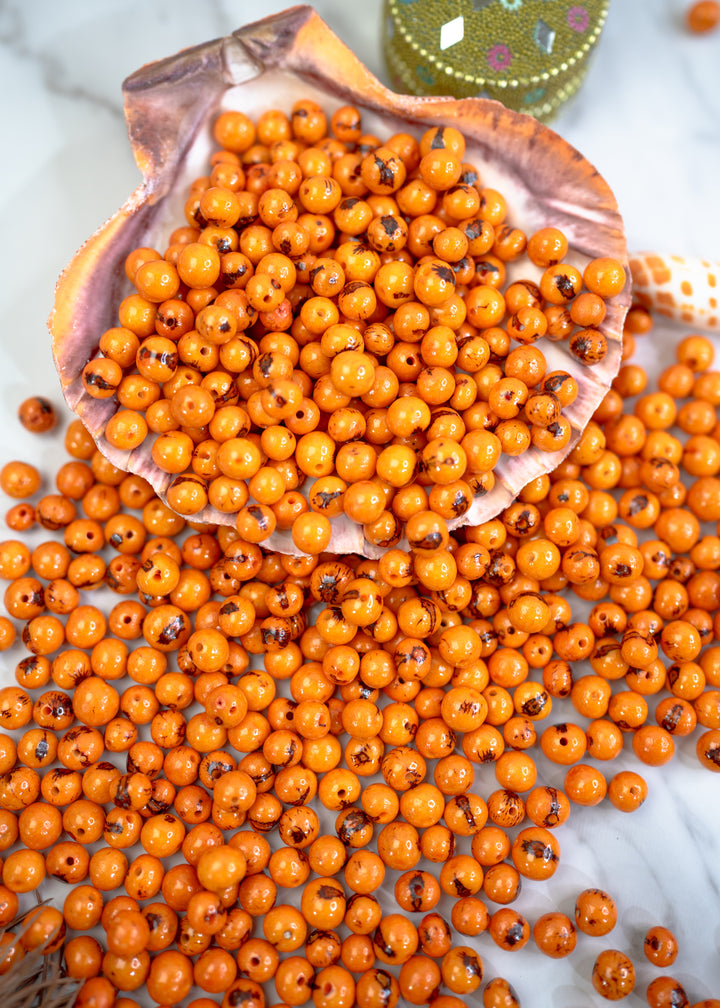 A big display of natural beads, orange acai beads for jewelry making.