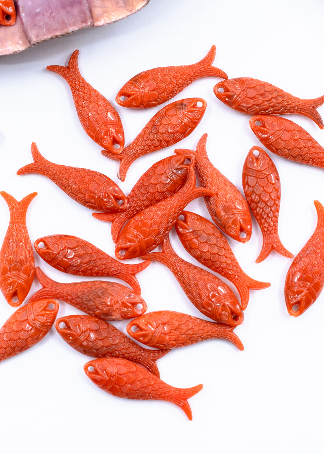 A group of small carved fish-shaped beads or pendants.