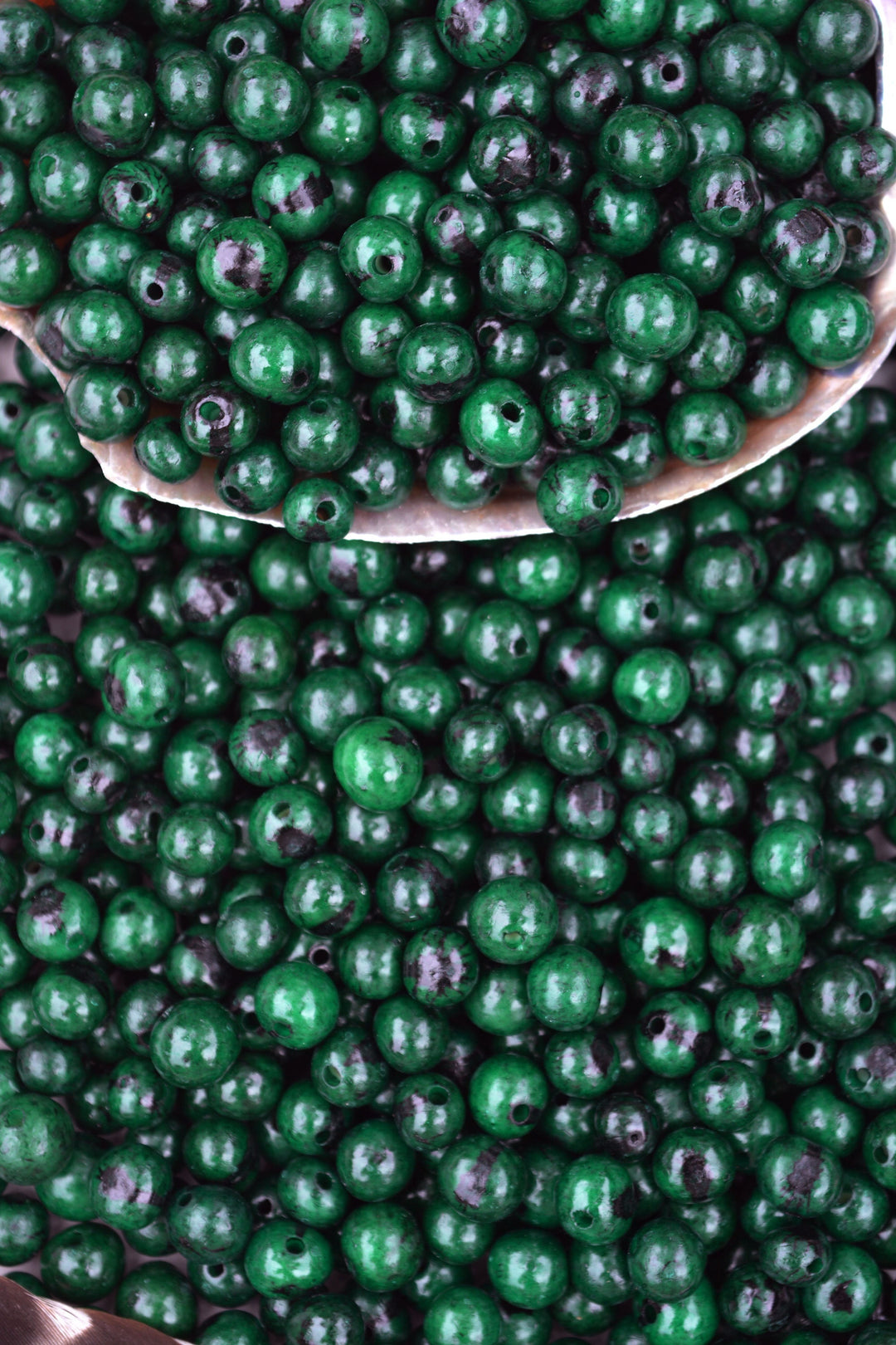Deep Emerald Green Acai Beads showing the large holes for jewelry making
