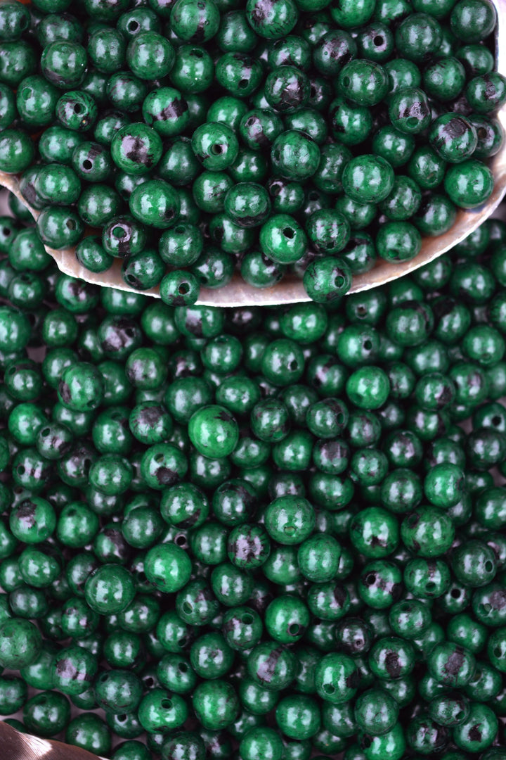 Deep Emerald Green Acai Beads showing the large holes for jewelry making