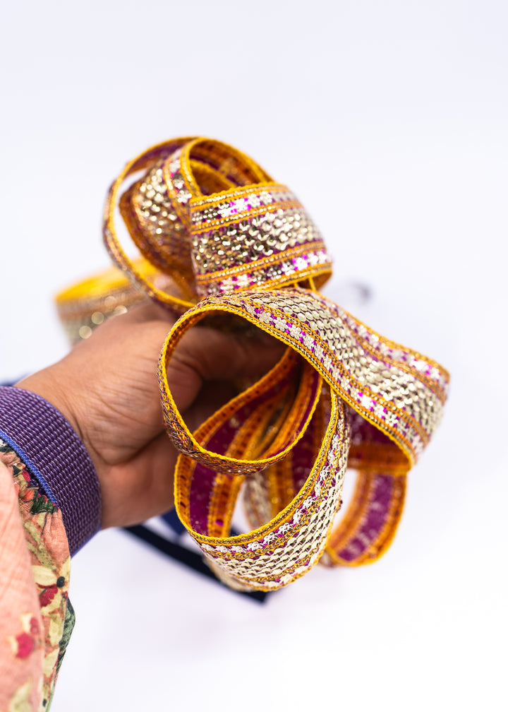 Gold sequin Indian trim with pink and yellow embroidered sari border detail. Decorative boho ribbon trim perfect for sewing, costumes, festival fashion, textile art, belly dance wear, handbags, pillows, and mixed media projects.