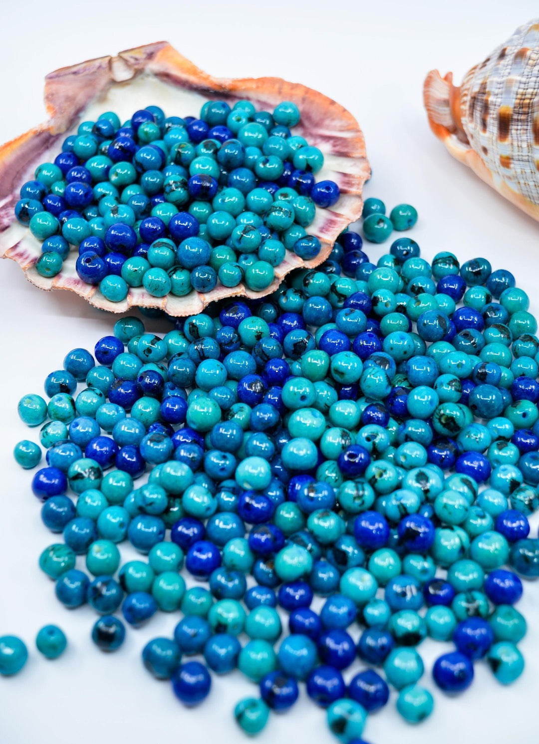 A collection of round blue acai beads of varying shades, some with a black line pattern.