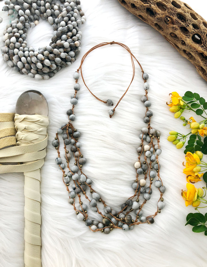 Natural Job’s Tears seed beads in earthy gray neutral tones featuring organic oval botanical beads for boho jewelry making, tribal necklaces, malas, meditation jewelry, mixed media art, and rustic artisan designs.