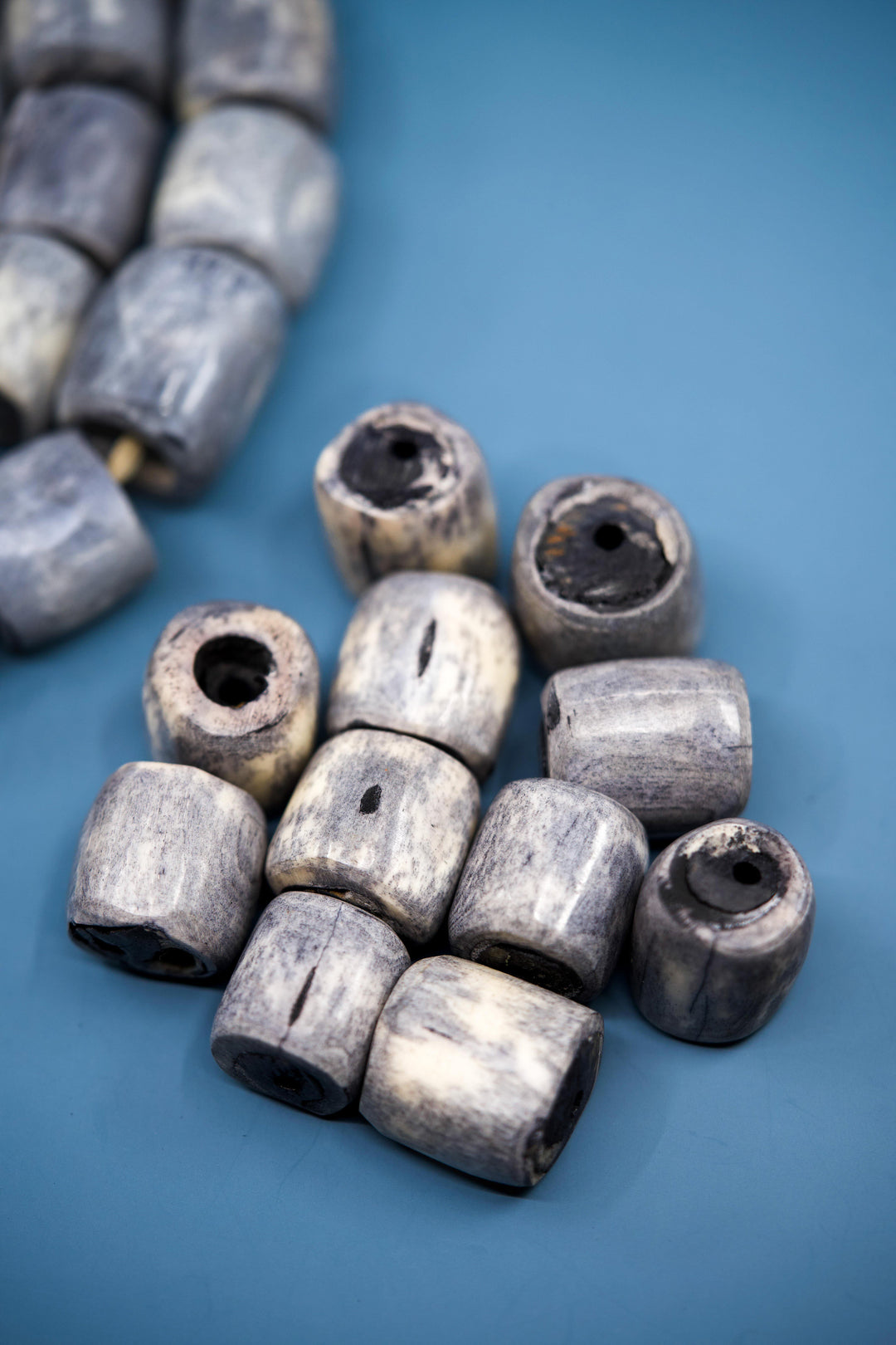 Blue gray African bone beads handmade in Kenya from recycled cow bone featuring oversized barrel shapes and large holes. Perfect for tribal jewelry making, boho necklaces, macrame, leather cord projects, braids, and artisan statement designs.