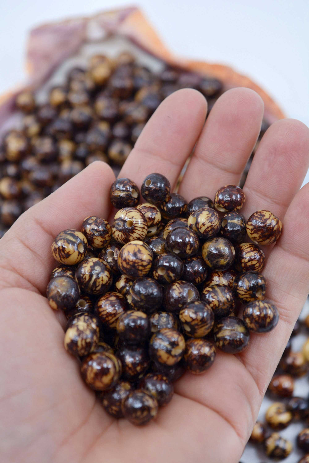 Natural Acai Beads in their natural color showing the brown color below the polishing.