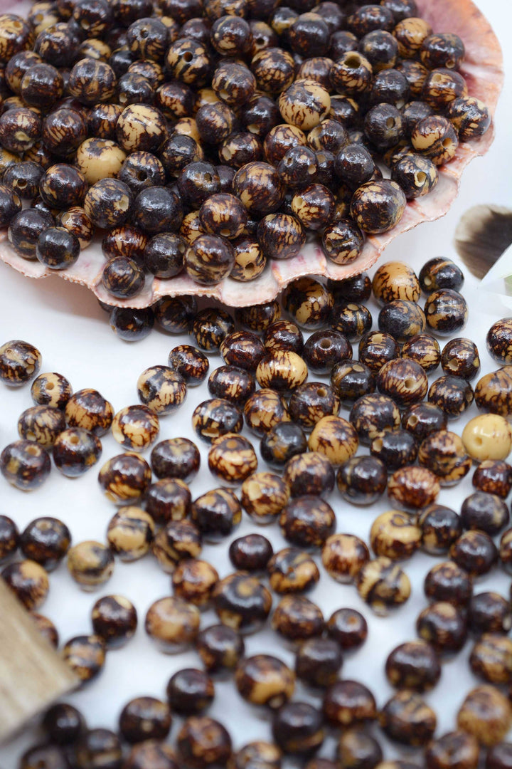 Natural Brown Acai Beads showing the large hole perfect for thicker threads for jewelry making.