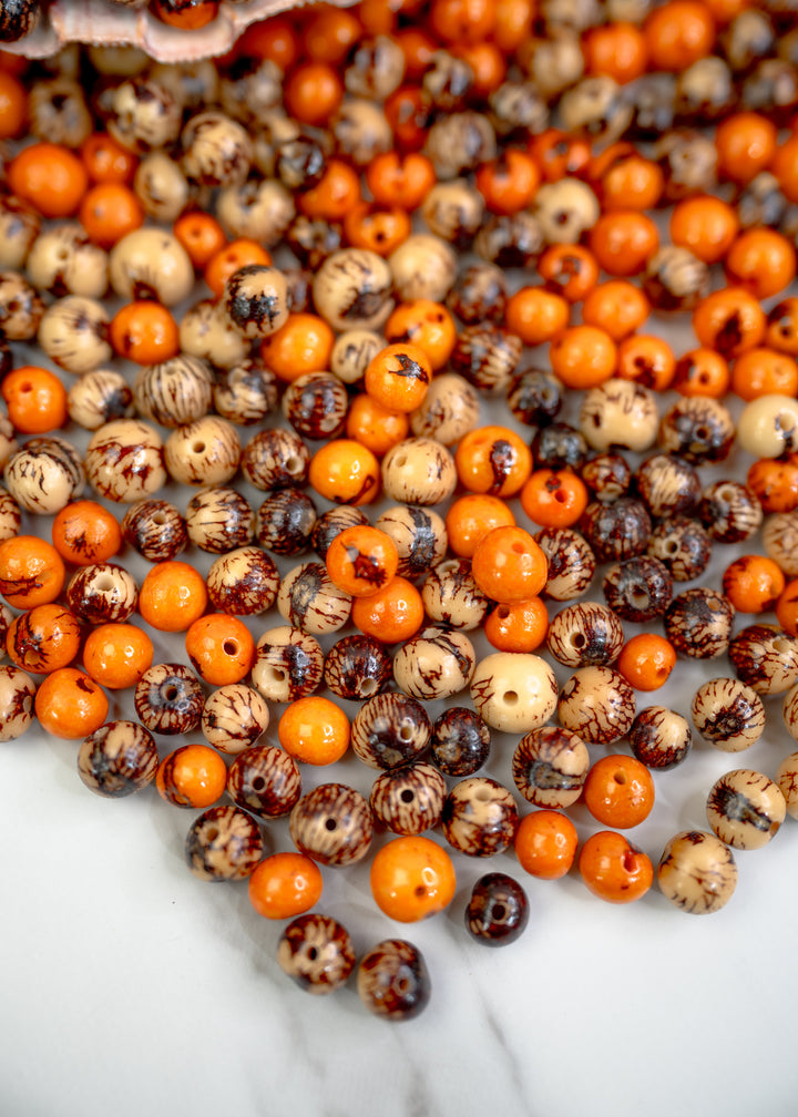 An assortment of natural acai beads displaying the size of the bead hole for jewelry makers.