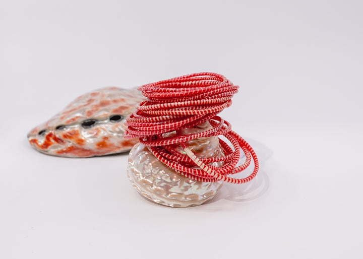 Red and white recycled flip flop bracelets handmade in Mali, West Africa featuring lightweight waterproof bangles perfect for boho arm stacks, beach jewelry, festival fashion, layered bracelets, artisan gifts, and colorful summer accessories.