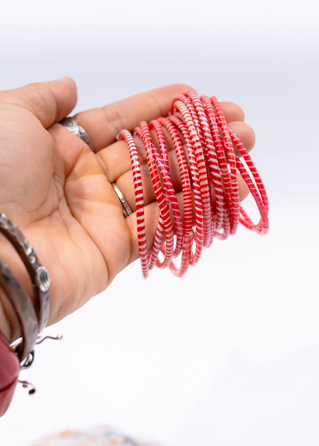 Red and white recycled flip flop bracelets handmade in Mali, West Africa featuring lightweight waterproof bangles perfect for boho arm stacks, beach jewelry, festival fashion, layered bracelets, artisan gifts, and colorful summer accessories.