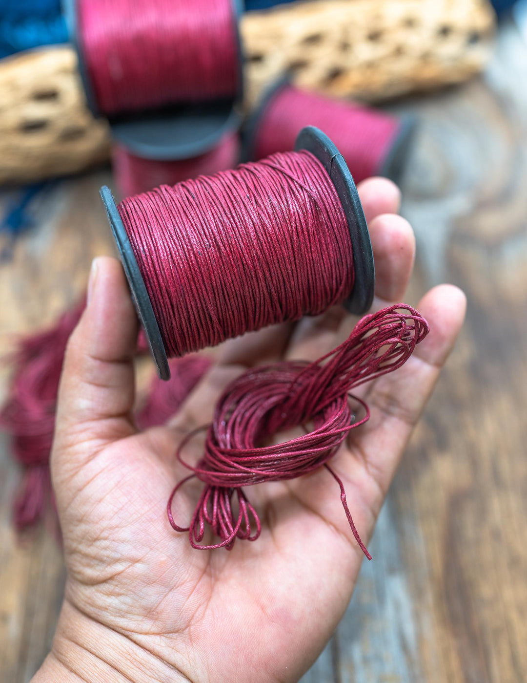 Red Velvet Braided Cotton Cord spool shown in the hands for cording size.