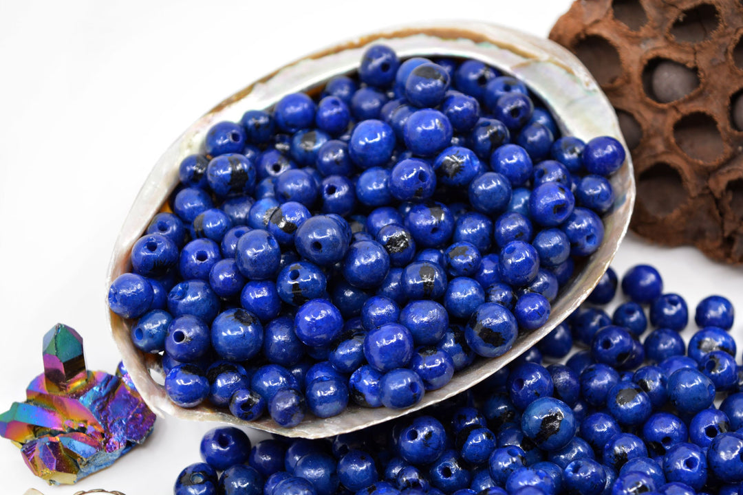 A close-up of acai beads in blue color showing the large holes used for jewelry making.