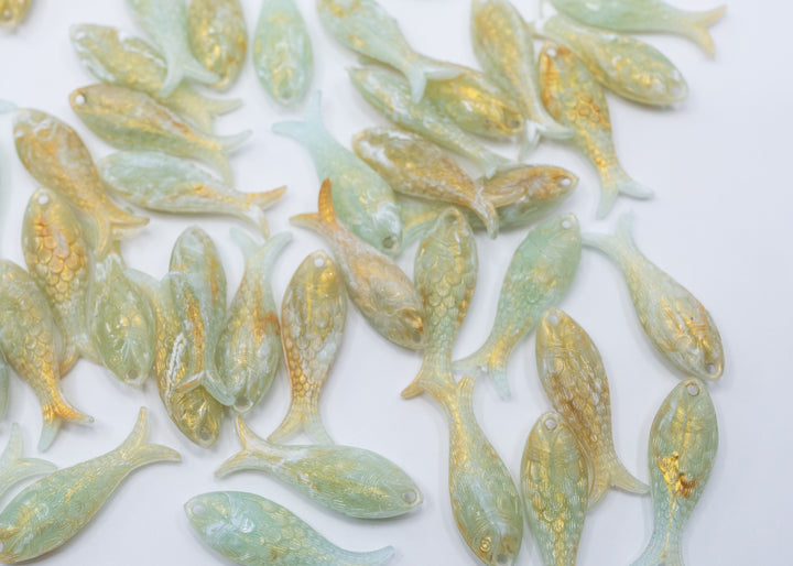 Seafoam Pearl Shimmer charms handmade from glitter German resin featuring a light green with golden glittery sardine pendants perfect for ocean jewelry, mermaidcore accessories, beach fashion, coastal earrings, whimsical summer jewelry, and festival-inspired designs. These fish ocean charms are waterproof and perfect for beach jewelry.