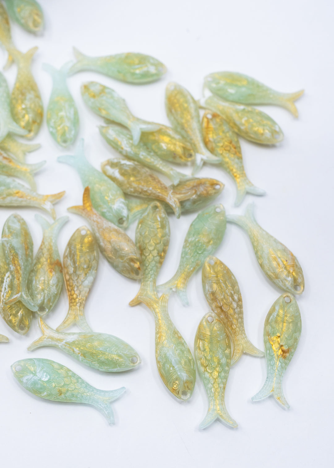 Seafoam Pearl Shimmer charms handmade from glitter German resin featuring a light green with golden glittery sardine pendants perfect for ocean jewelry, mermaidcore accessories, beach fashion, coastal earrings, whimsical summer jewelry, and festival-inspired designs. These fish ocean charms are waterproof and perfect for beach jewelry.
