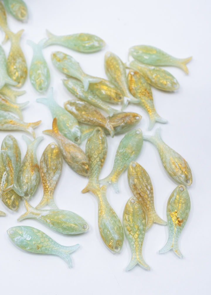 Seafoam Pearl Shimmer charms handmade from glitter German resin featuring a light green with golden glittery sardine pendants perfect for ocean jewelry, mermaidcore accessories, beach fashion, coastal earrings, whimsical summer jewelry, and festival-inspired designs. These fish ocean charms are waterproof and perfect for beach jewelry.