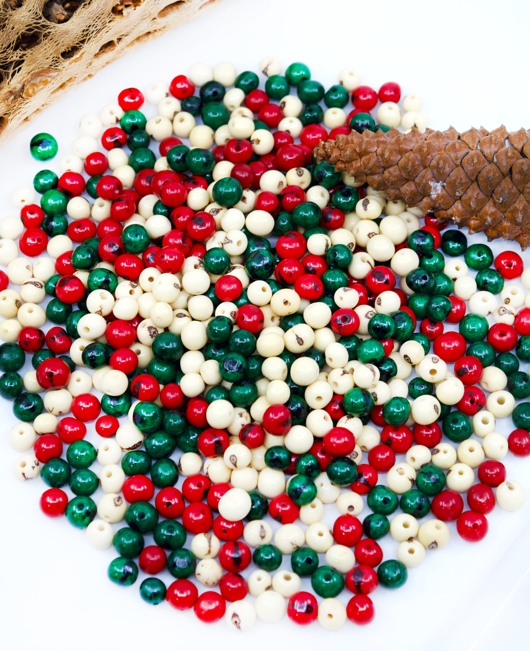A mic of green, white and red acai beads for making jewelry.