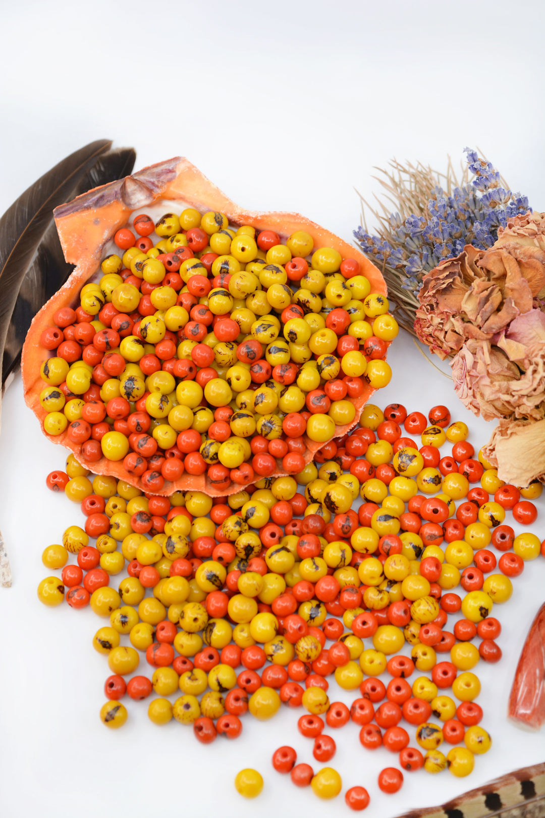 Beautiful display of Yellow and Orange Acai Beads in a white background.