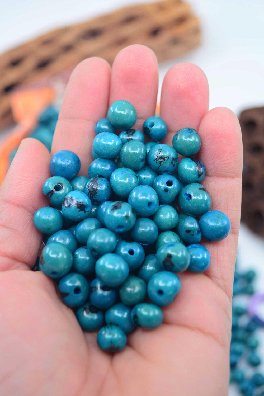 Deep Turquoise Blue Acai Beads close-up in the hands.