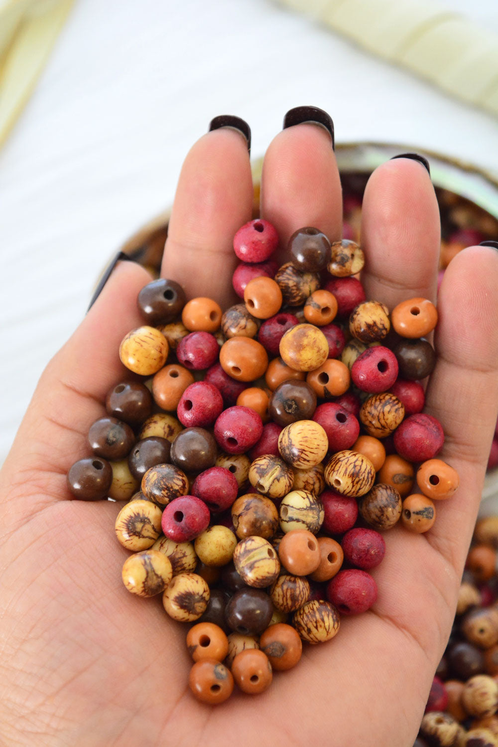Close-up of Earth Tones acai beads in a hand.