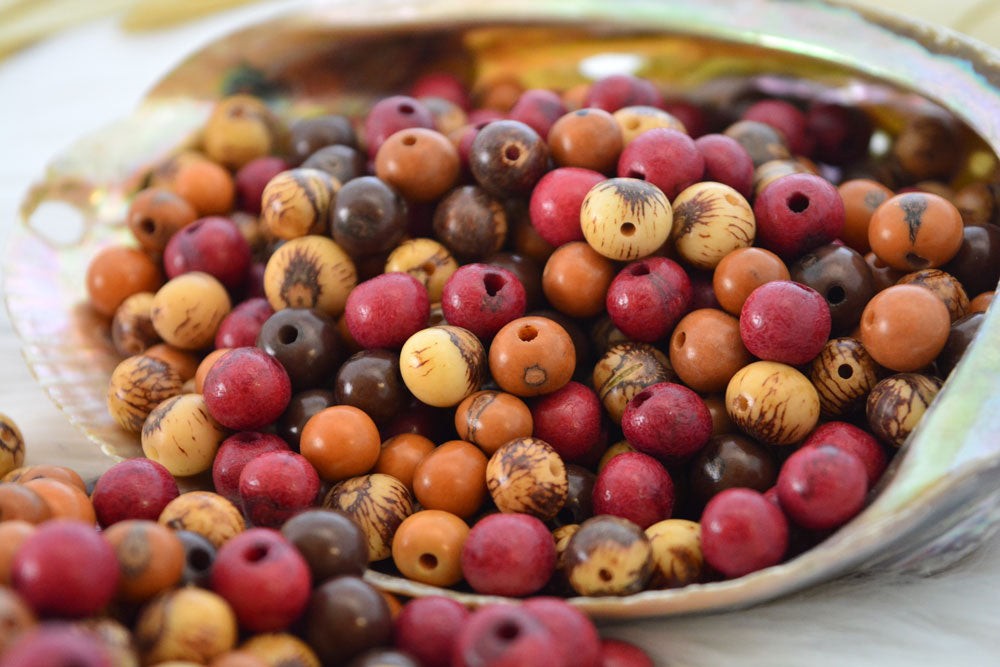 Close-up of natural acai beads showing the natural marking and holes of the beads for jewelry making.