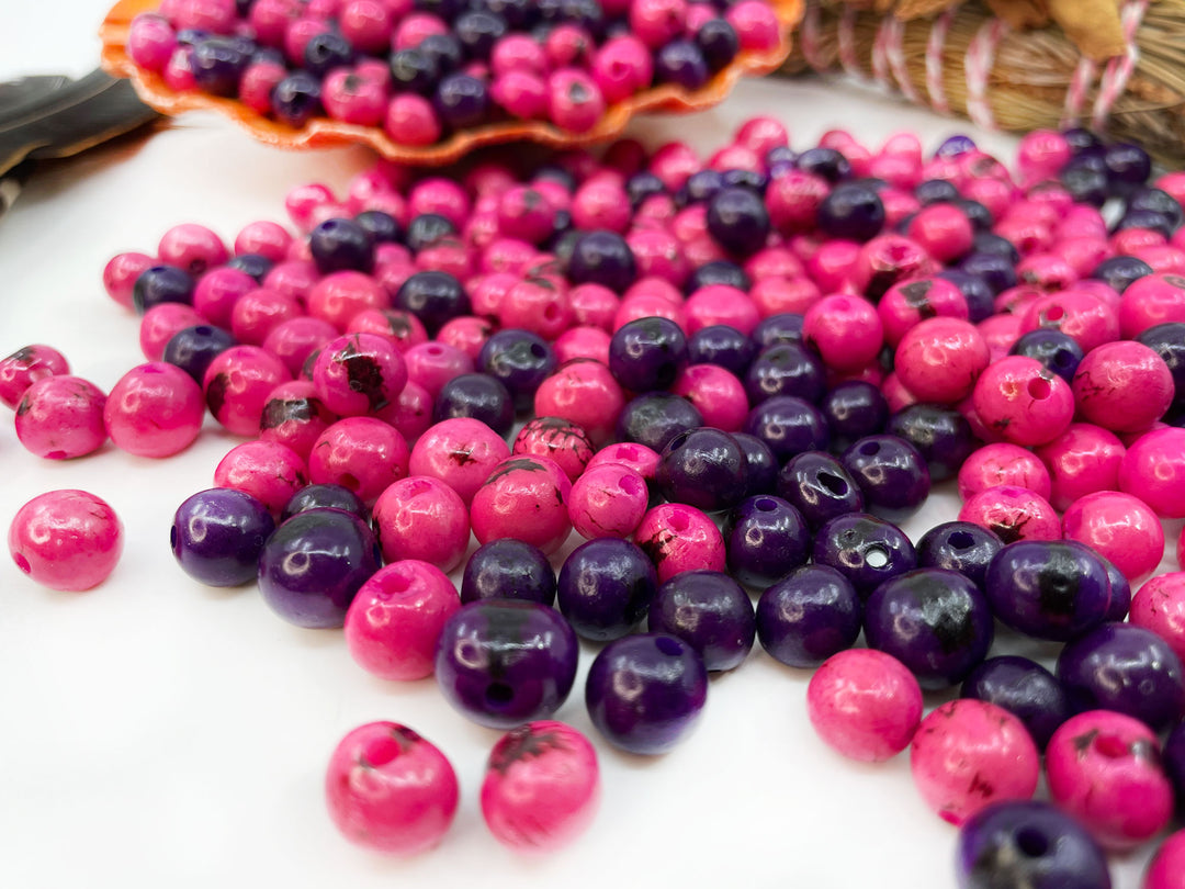 Close-up of pink and purple acai beads showing the different bead sizes.