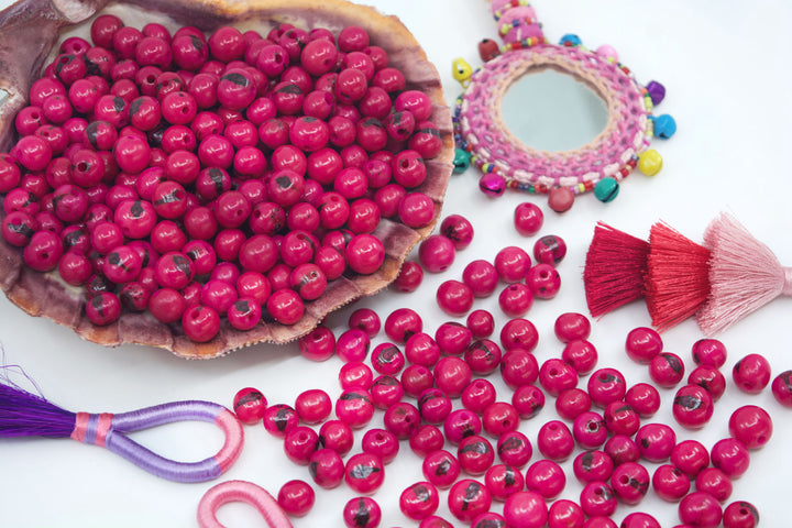 Fuchsia Pink Acai Beads close-up of beads in a seashell.