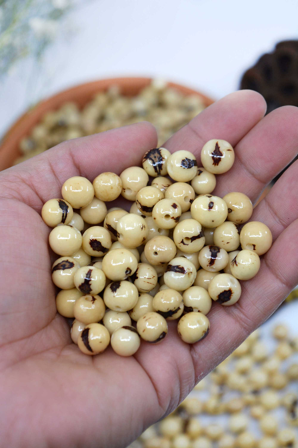 Natural Cream Real Acai Beads close-up in the hands.