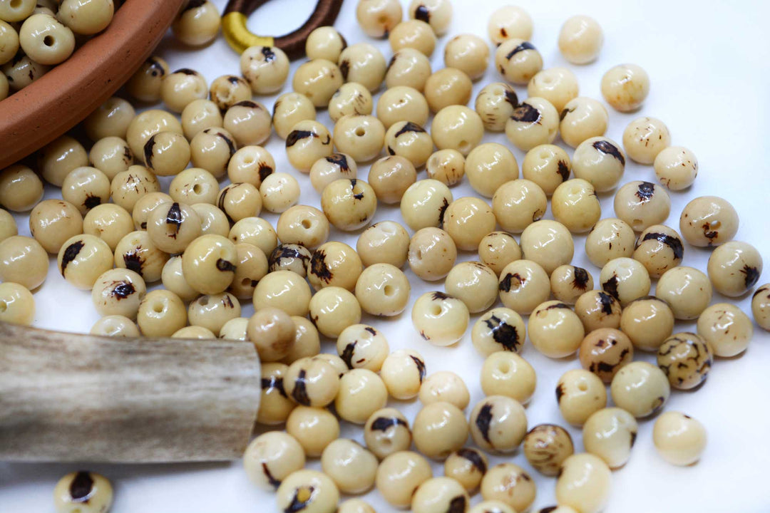Natural Cream Real Acai Beads showing the variance of size of the beads.