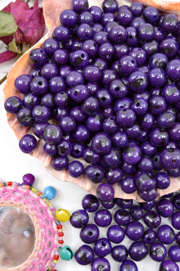 Violet Purple Acai Beads displayed in a seashell