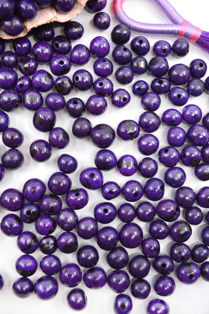 Violet Purple Acai Beads showing the variance in size.